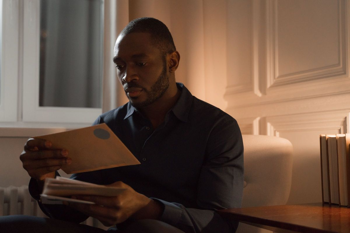 a man reading a letter in warm evening light